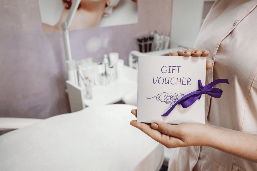 beauty clinic professional holding gift voucher card