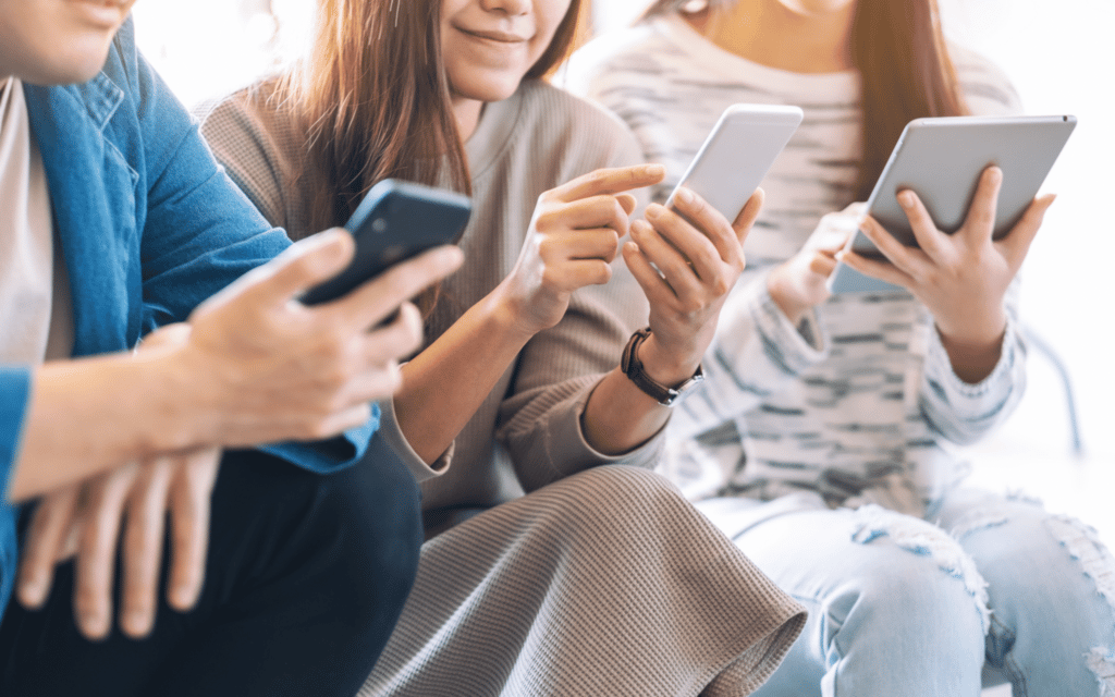 three people receiving and reading text on phones and tablet