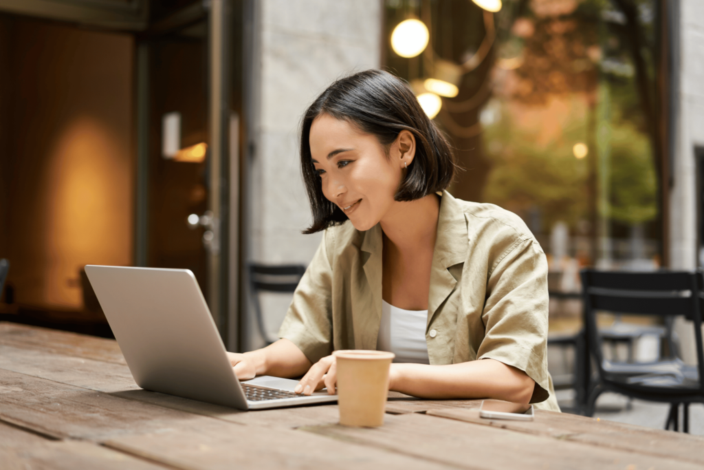 woman in laptop in cafe working with cup of coffee