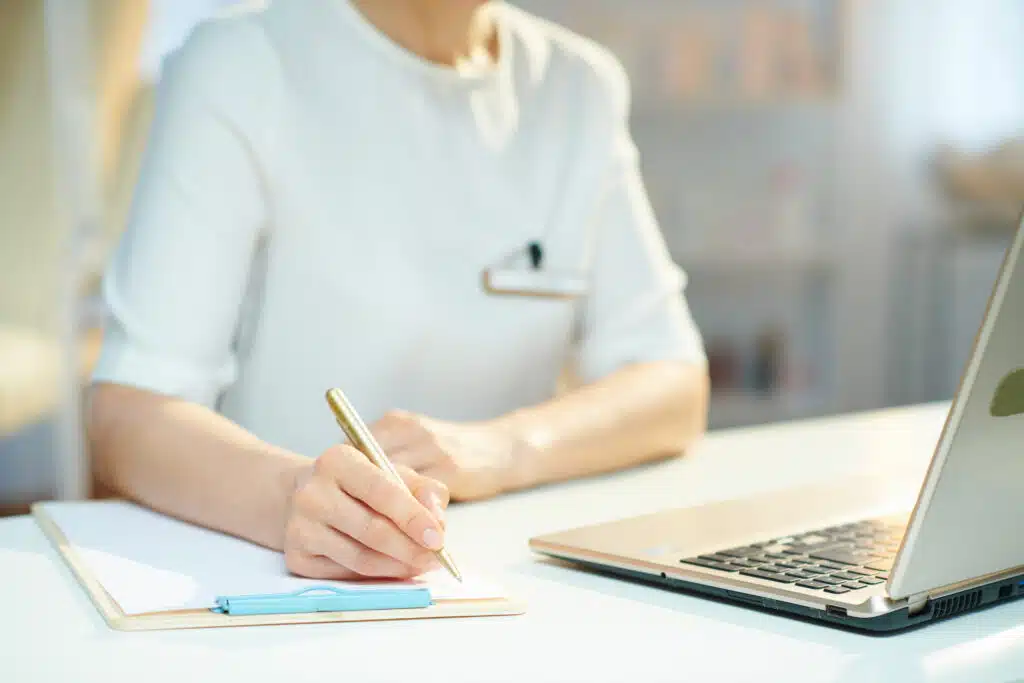 nail salon owner with a laptop and notebook bookkeeping and working on finances
