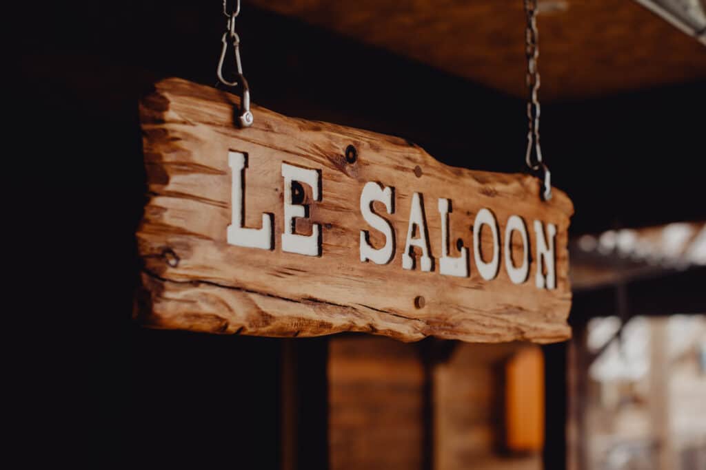 thematic west salon front with wooden hangning sign le saloon