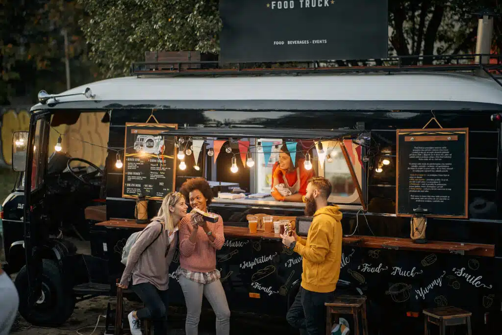people eating in front of a food truck