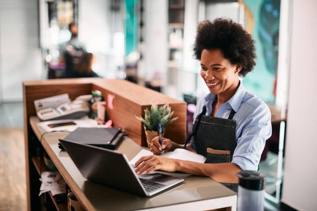 hair salon professional working on laptop computer