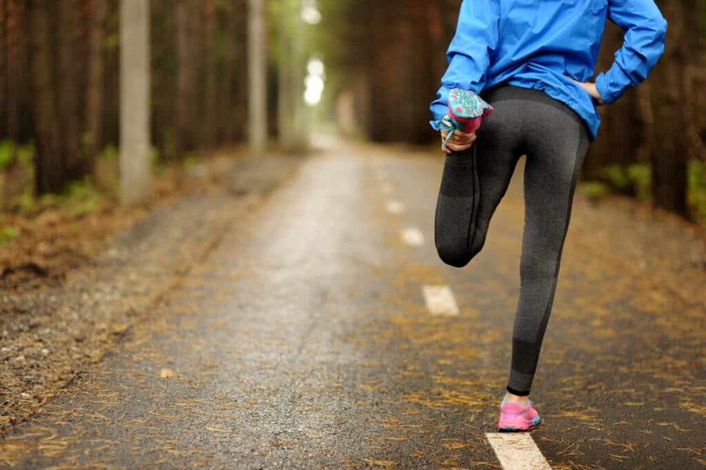 person stretching preparing to jog in a forest