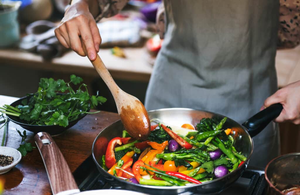 woman cooking stir fried vegetables