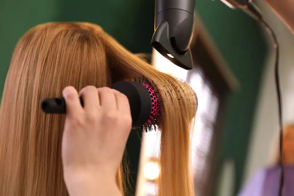 hair stylist blowing out client's hair