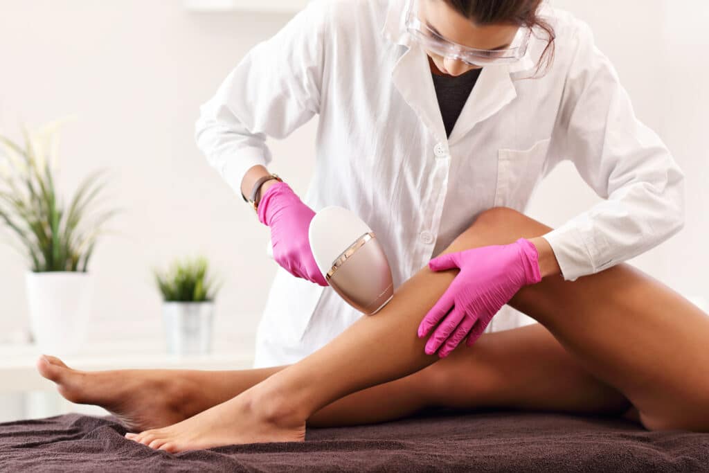 professional removing leg hair from client with professional equipment